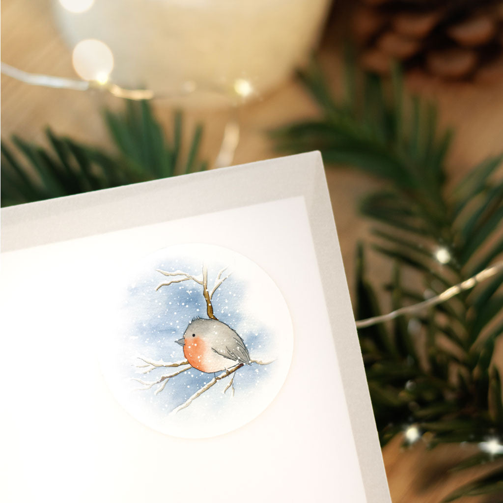 Winterlicher Aufkleber mit Rotkehlchen auf weißem Umschlag – festliche Dekorationsidee für Karten oder zum stilvollen Verpacken von Weihnachtsgeschenken.