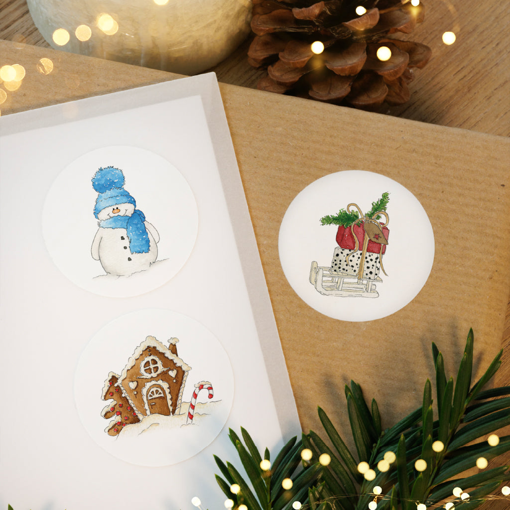 Runde Weihnachtsaufkleber mit Schneemann und Lebkuchenhaus Motiv verschönern Briefumschläge und Geschenke im Advent.