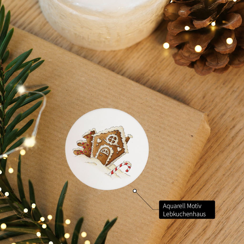 Runder Aufkleber mit handgemaltem Lebkuchenhaus Aquarell Motiv als Dekoration für Weihnachtspost.