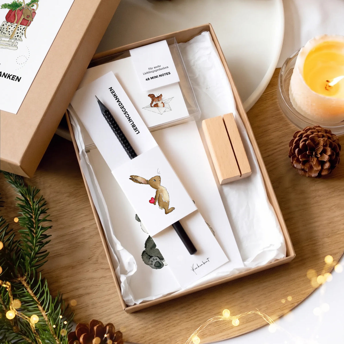 Geöffnete Geschenkbox Weihnachten mit 12 Karten mit Aquarell Motiv, 48 Mini Notes, Holz-Kartenhalter und schwarzem Design Bleistift