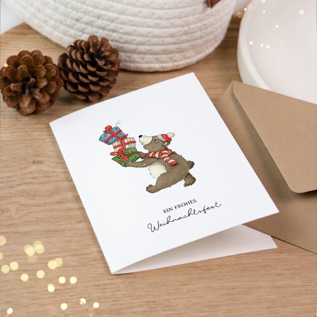 Hochwertige Klappkarte für Weihnachten mit handgemaltem Bär Aquarell Motiv neben winterlichen Tannenzapfen.