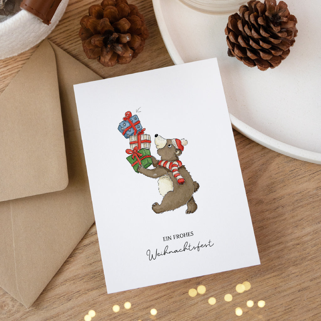 Weihnachtskarte mit Bär und Geschenken auf Holztisch dekoriert für stimmungsvolle Weihnachtsgrüße.