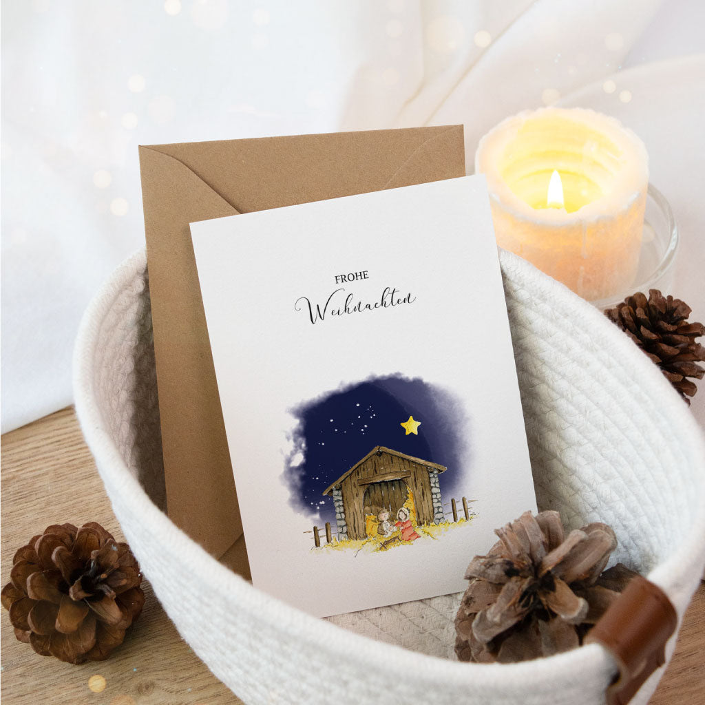 Klappkarte mit handgemaltem Aquarellmotiv einer Krippenszene vor dunklem Nachthimmel, kombiniert mit dem Schriftzug „Frohe Weihnachten“ – liebevoll gestaltete Weihnachtskarte für die Adventszeit.