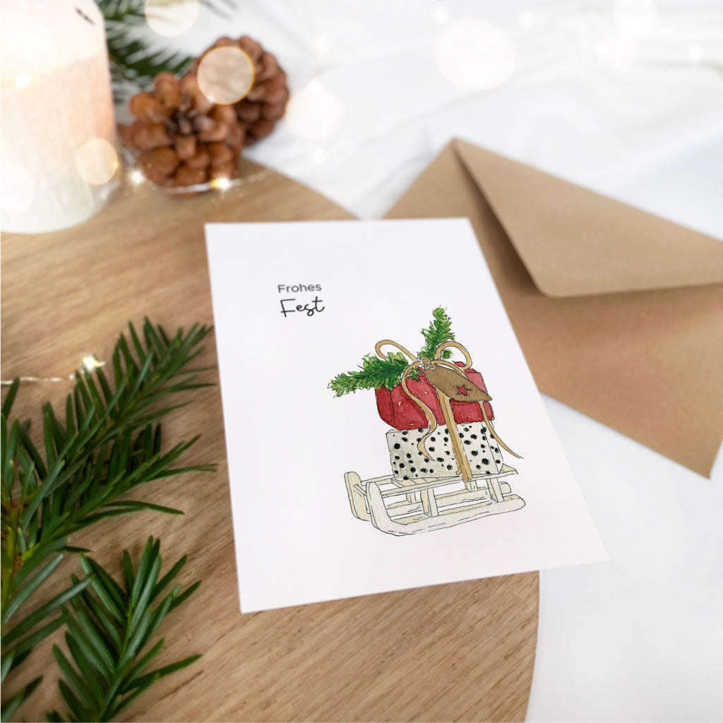 Weihnachtskarte mit Aquarell Motiv Geschenke auf Schlitten