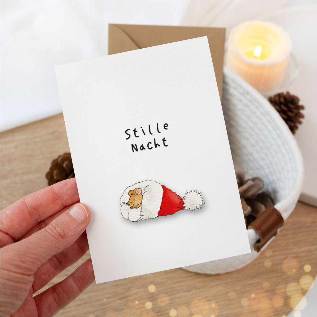 Nahaufnahme der Karte mit schlafender Maus in Weihnachtsmannmütze, gehalten in der Hand – ideal für persönliche Weihnachtsgrüße oder zum Geschenke verpacken.
