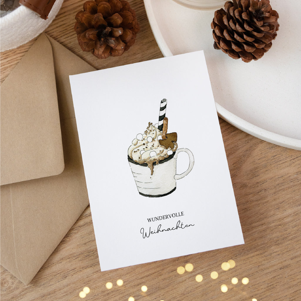 Stilvolle Weihnachtskarte auf Holztisch mit Heißgetränk Aquarell Motiv und geschwungenem Schriftzug Wundervolle Weihnachten.