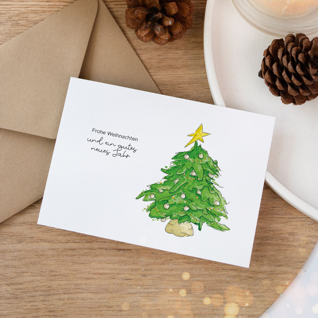 Aquarellkarte mit geschmücktem Weihnachtsbaum und dem Spruch „Frohe Weihnachten und ein gutes neues Jahr“ – ideal für deine Weihnachtspost.