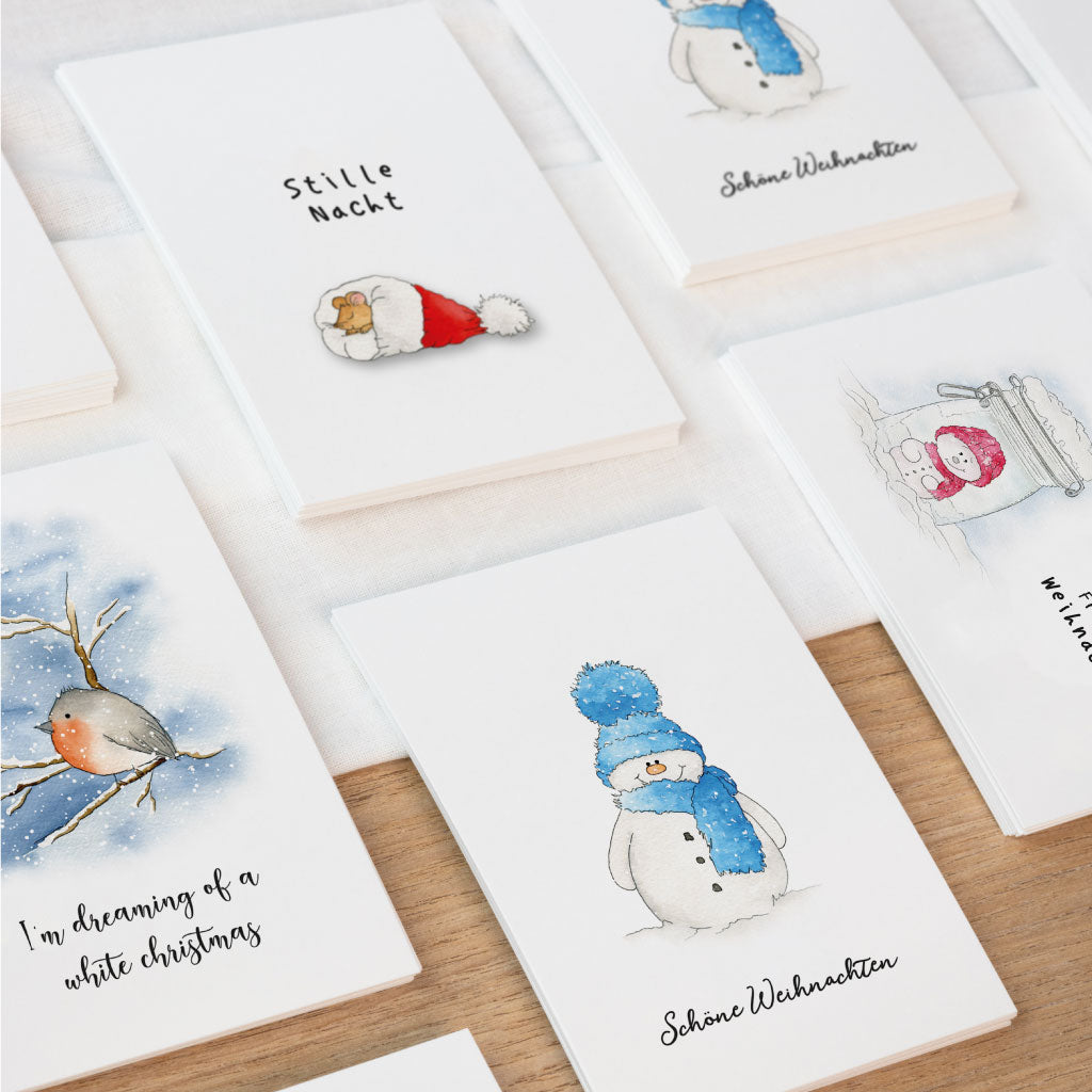 Weihnachtskarten Set mit vier handgemalten Aquarell Karten – winterliche Motive wie Schneemann, Vogel, Weihnachtsmütze und Einmachglas mit Schneemann, perfekt für liebevolle Grußkarten zu Weihnachten.