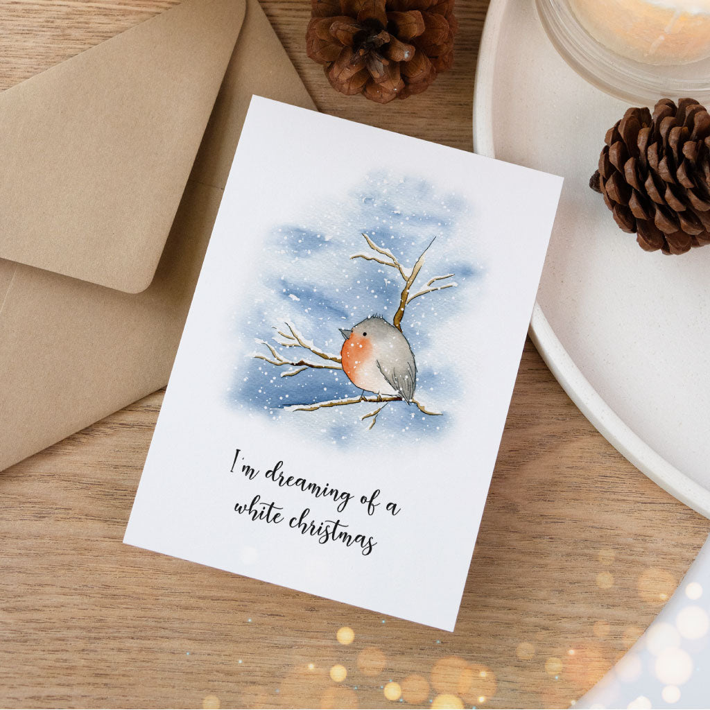 Aquarell Karte mit Rotkehlchen auf einem verschneiten Ast und dem Text „I'm dreaming of a white Christmas“ – stimmungsvolle Ergänzung im Weihnachtskarten Set.