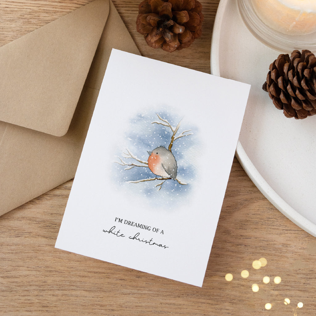 Weihnachtsgrußkarte mit einem Rotkehlchen auf einem Ast. Winterliche Postkarte liebevoll dekoriert.