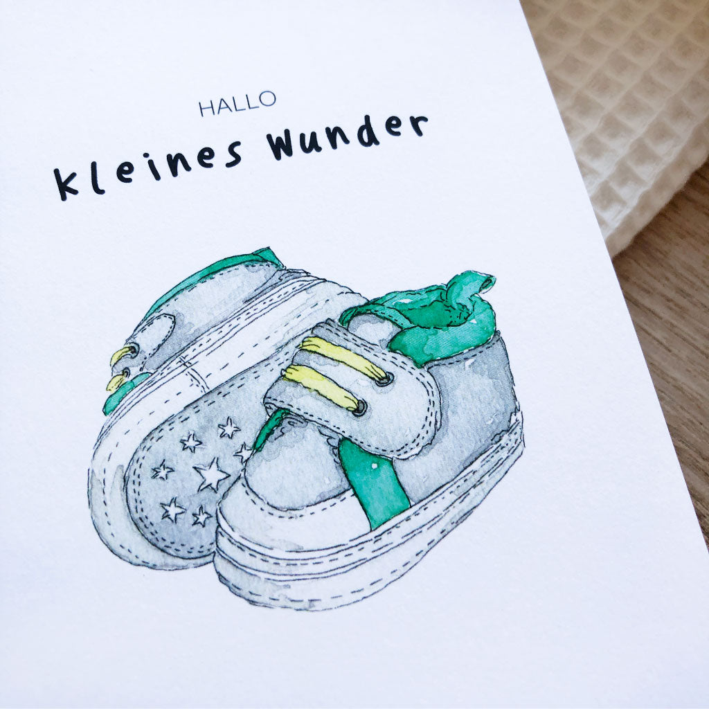 Detailaufnahme des Motivs: zwei graue und türkise Babyschuhe