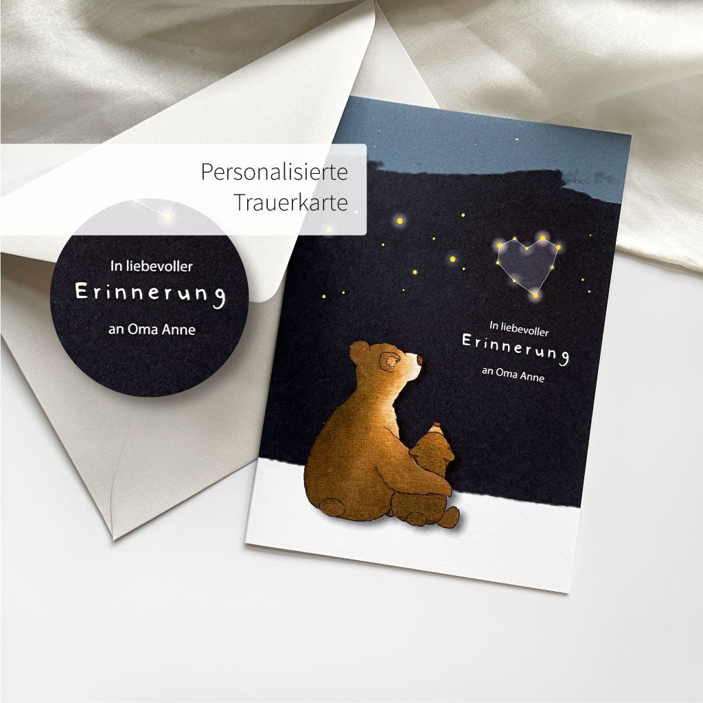 Personalisierte Trauerkarte mit Bären Motiv liegt neben hellgrauem Umschlag