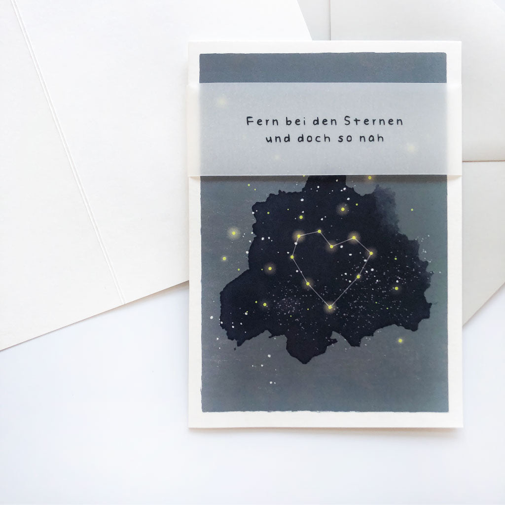 Trauerkarte „Fern bei den Sternen" liegt auf aufgeklappter Klappkarte