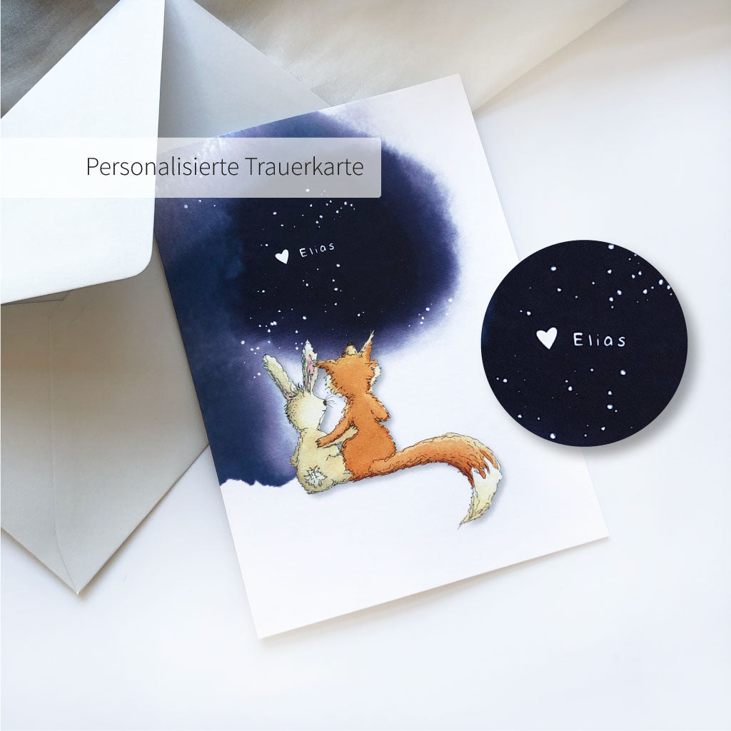 Personalisierte Trauerkarte mit Fuchs und Hase Motiv liegt auf hellgrauem Kuvert