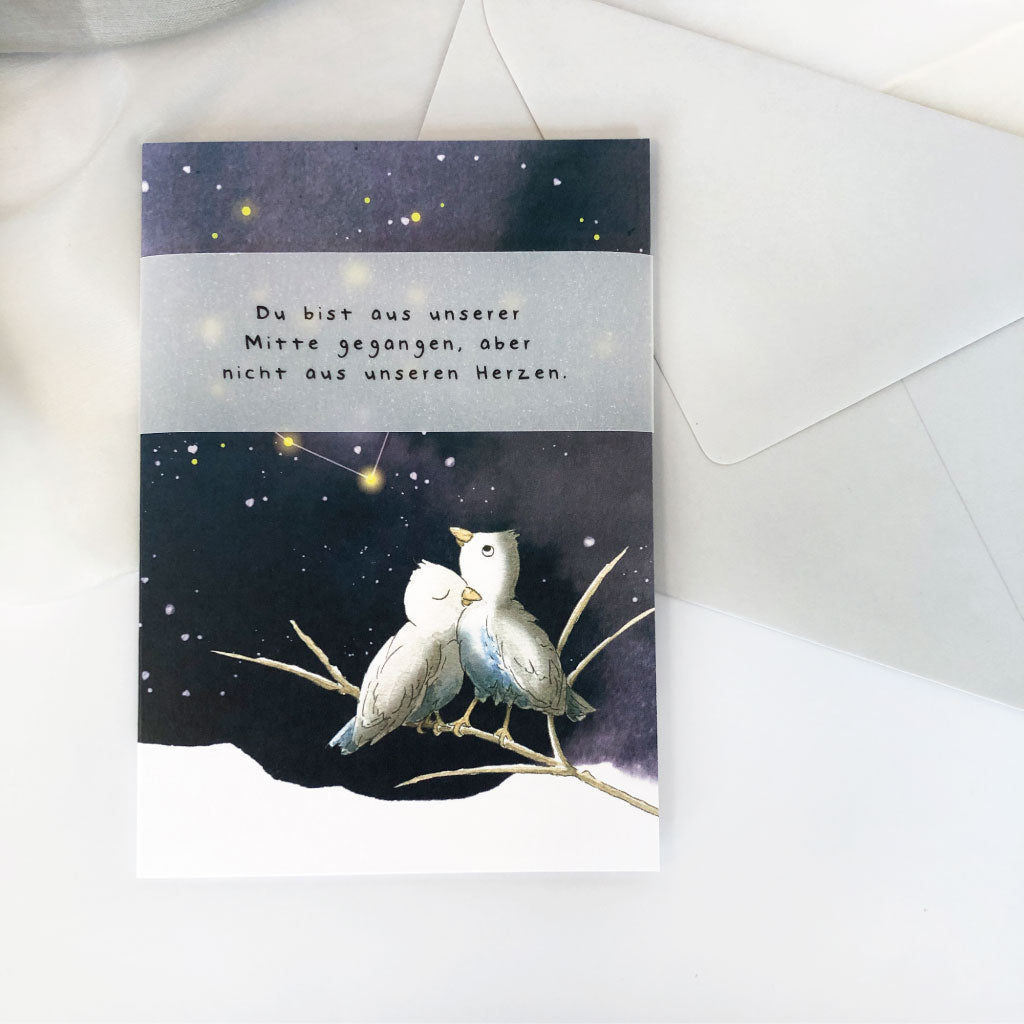 Trauerkarte mit Vogel Motiv und Banderole liegt auf hellgrauem Umschlag